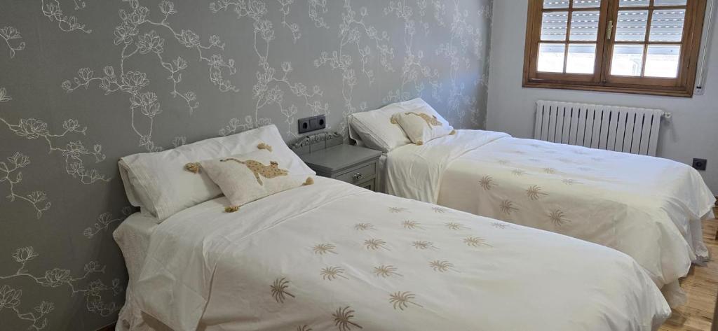 a bedroom with two beds with white sheets and wallpaper at Maruja Rural 2 in Sober