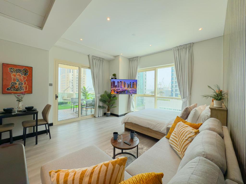 a large living room with a bed and a couch at Stylish Studio Apartment with large Balcony and Sea Views, free Parking, Dubai Marina - JBR in Dubai