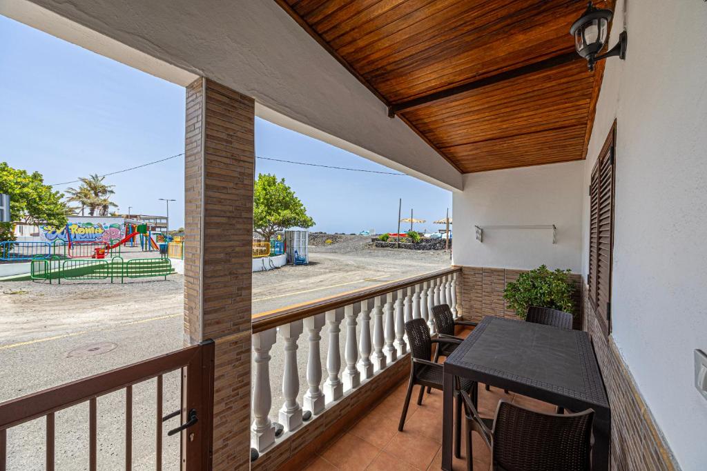 balcón con mesa y sillas y parque infantil en Casita Pedro El Remo, en Los Llanos de Aridane