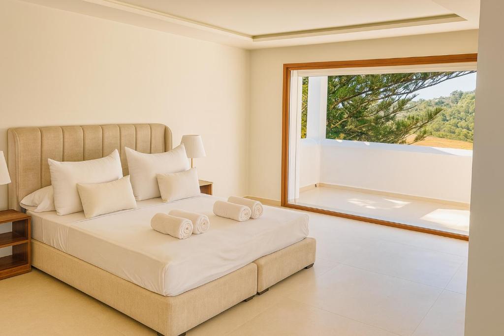 a bedroom with a bed with a large window at Villa Jasmin 12 in M'diq