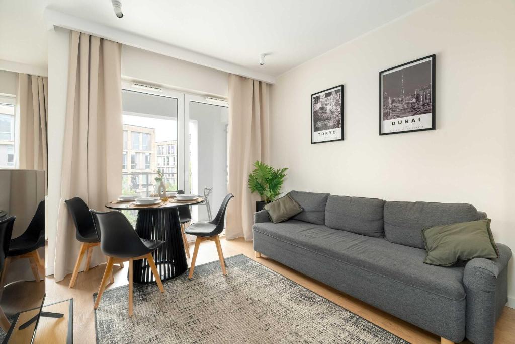 una sala de estar con un sofá y una mesa en Modern Studio with Parking near Lake Malta by Noclegi Renters, en Poznan