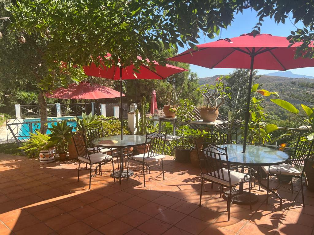 eine Gruppe von Tischen und Stühlen mit Sonnenschirmen in der Unterkunft Casa Simba B&B in Estepona