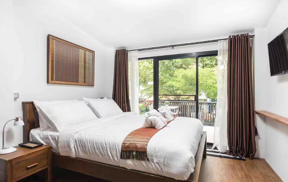 a bedroom with a bed with a teddy bear on top of it at Baan Ploen Dee - Wat Arun in Bangkok