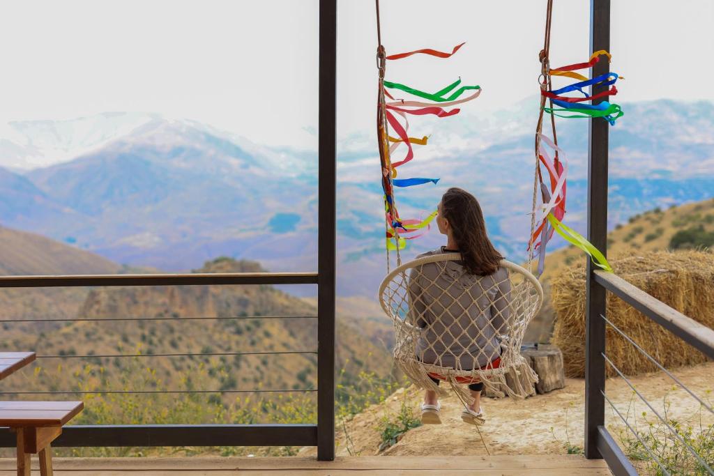 a woman sitting in a chair looking at the mountains at Sareni in Areni