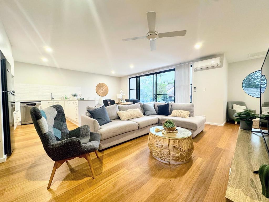 a living room with a couch and a table at Stylish 4BR Retreat with Water Views in Port Macquarie