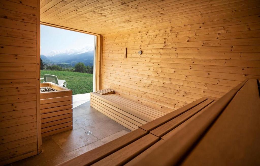 una sauna con una grande finestra su una parete in legno di Panorama - Vall di Fiemme a Carano