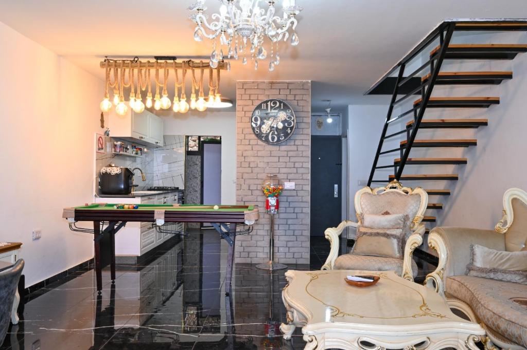 sala de estar con mesa de ping pong y escaleras en נופש תות - דירת אירוח בלב טבריה עם ג'קוזי ספא, en Tiberíades