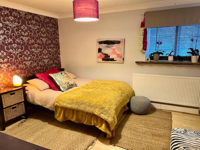 a bedroom with a bed with a yellow blanket at Bang central homestay with 2 x gorgeous double rooms, bathroom & kitchen use in Brighton & Hove
