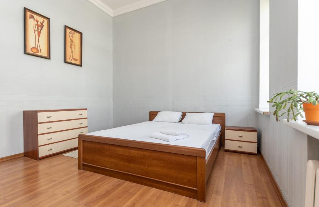 基辅Простора 3 кімнатна біля Майдану Незалежності的一间卧室配有一张铺有木地板的白色床单。