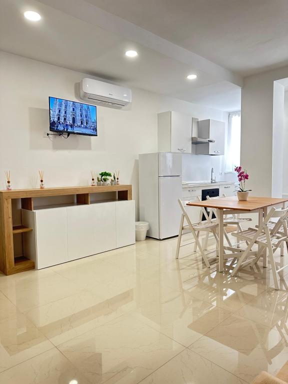 a kitchen with a dining table and a kitchen with white cabinets at CMcasevacanze in Milan