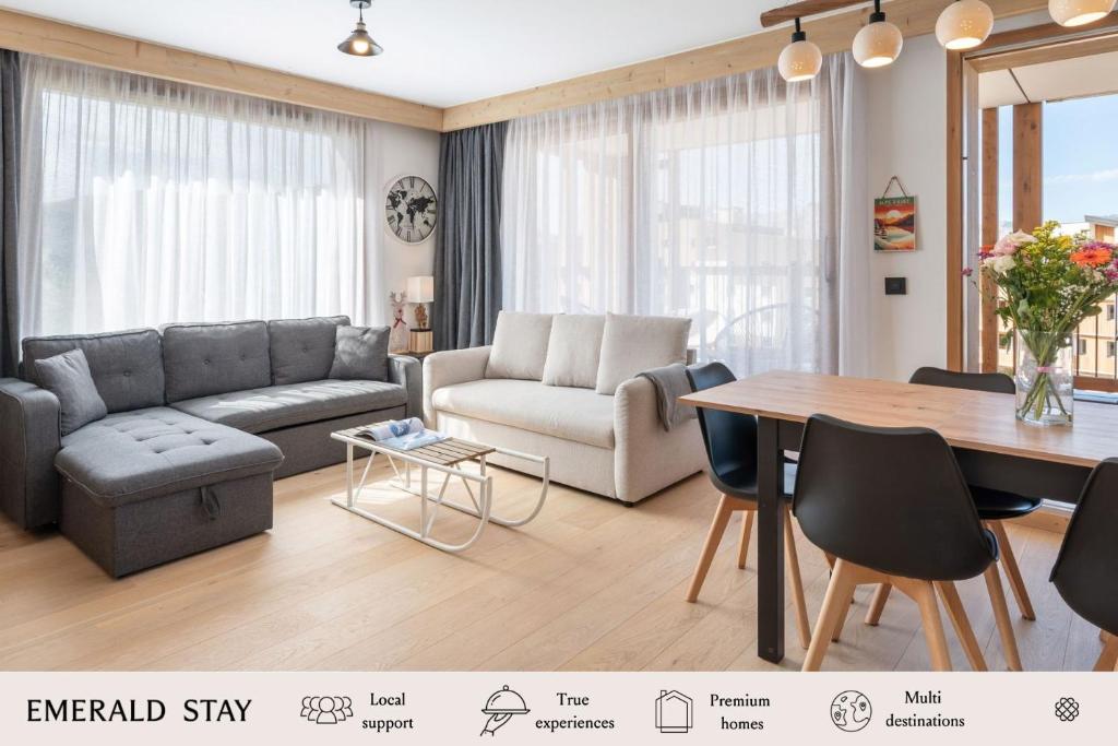 un soggiorno con un divano e un tavolo di Apartment Vallejo Alpe D'Huez - by EMERALD STAY a LʼHuez