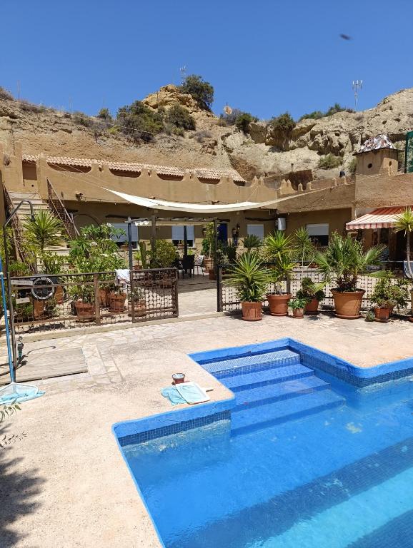 a swimming pool in front of a building at Nick's Cave, Bed and Breakfast with a difference in Cuevas del Almanzora
