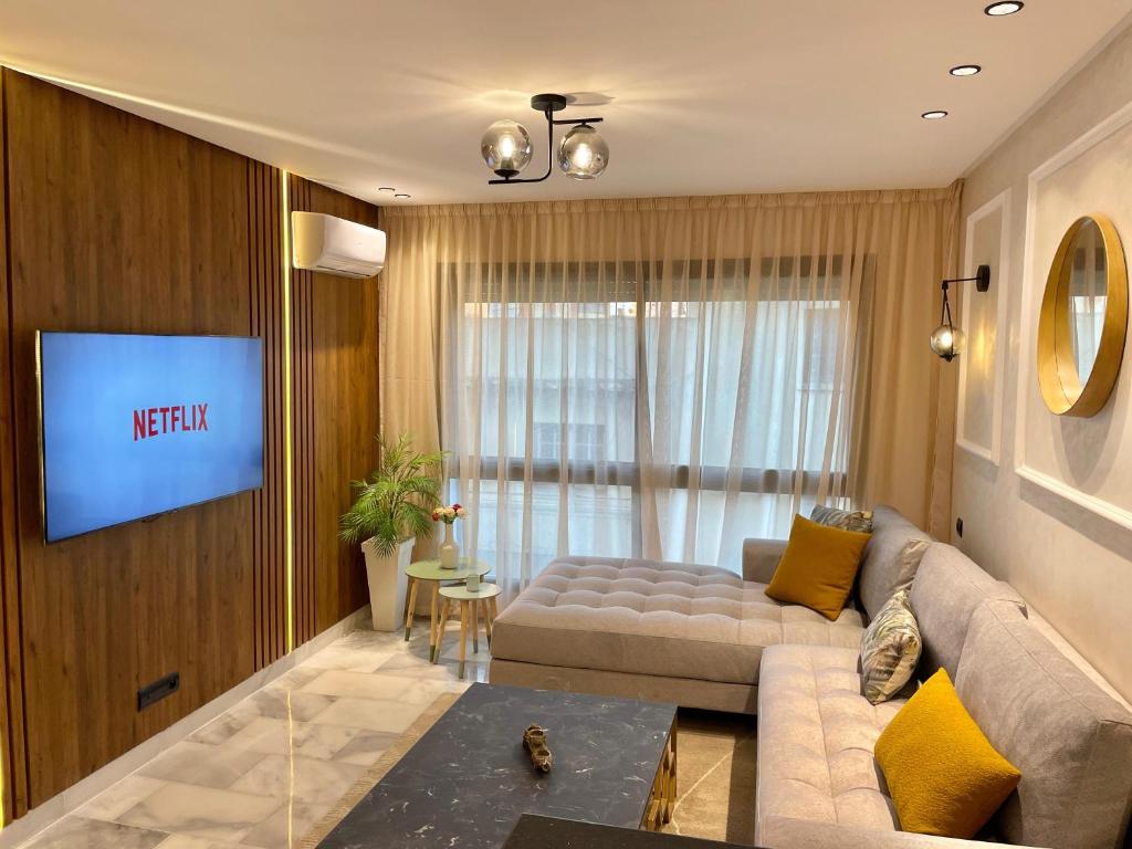 ein Wohnzimmer mit Sofa und Fernseher in der Unterkunft D1115 Studio au Cœur de Casablanca Proximité et Confort1 in Casablanca