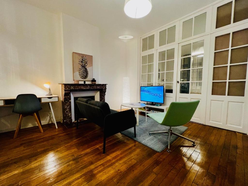a living room with a desk with a computer and chairs at T2 avec beaucoup de cachet in Saint-Quentin