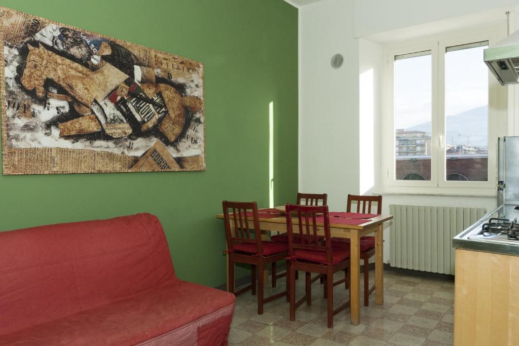 a living room with a red couch and a table and chairs at Viale Mezzetti - 1.3 by Ospitaci in Foligno
