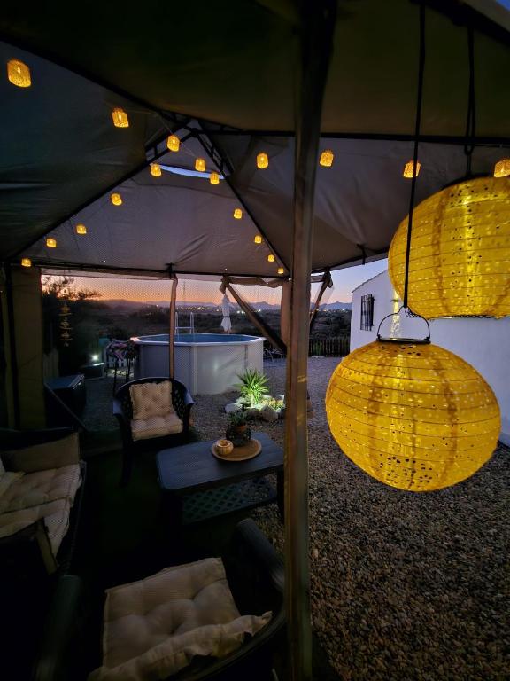 a tent with two lights and a table and chairs at Cortijo El Ancla in Albox