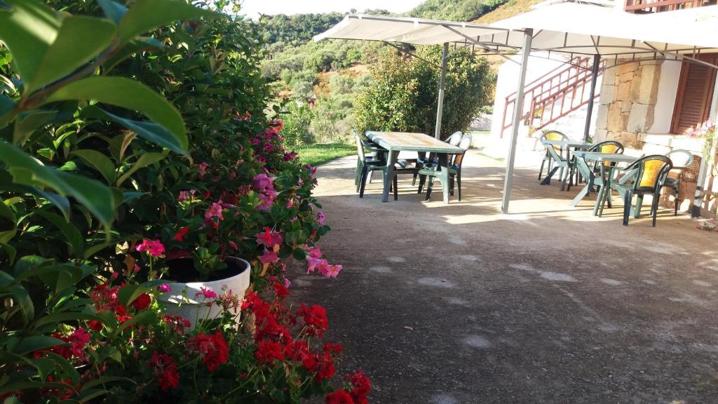 a patio with a table and chairs and flowers at Bandi House in San Teodoro
