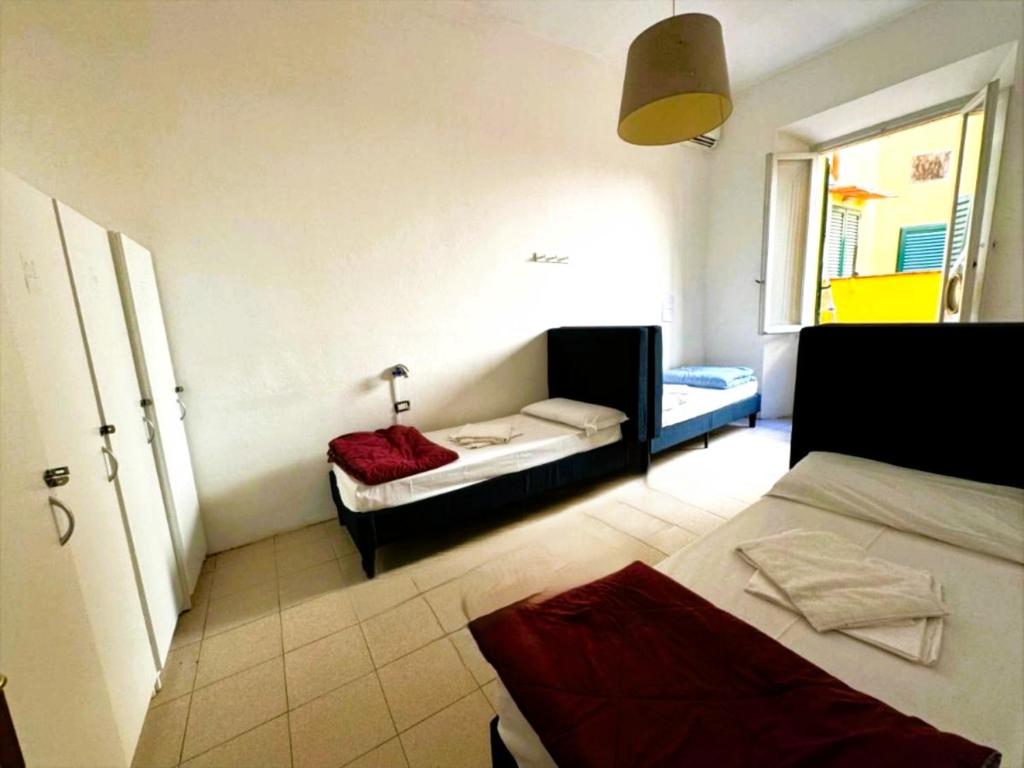 a small room with two beds and a window at My Friends in Florence