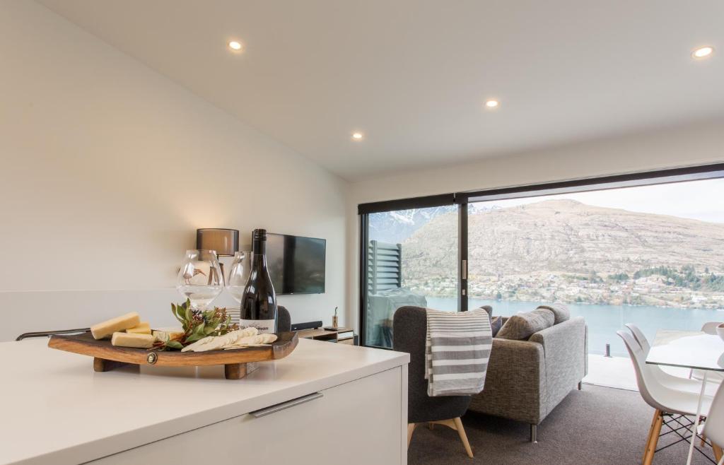 a kitchen with a living room with a large window at Highland Views in Queenstown