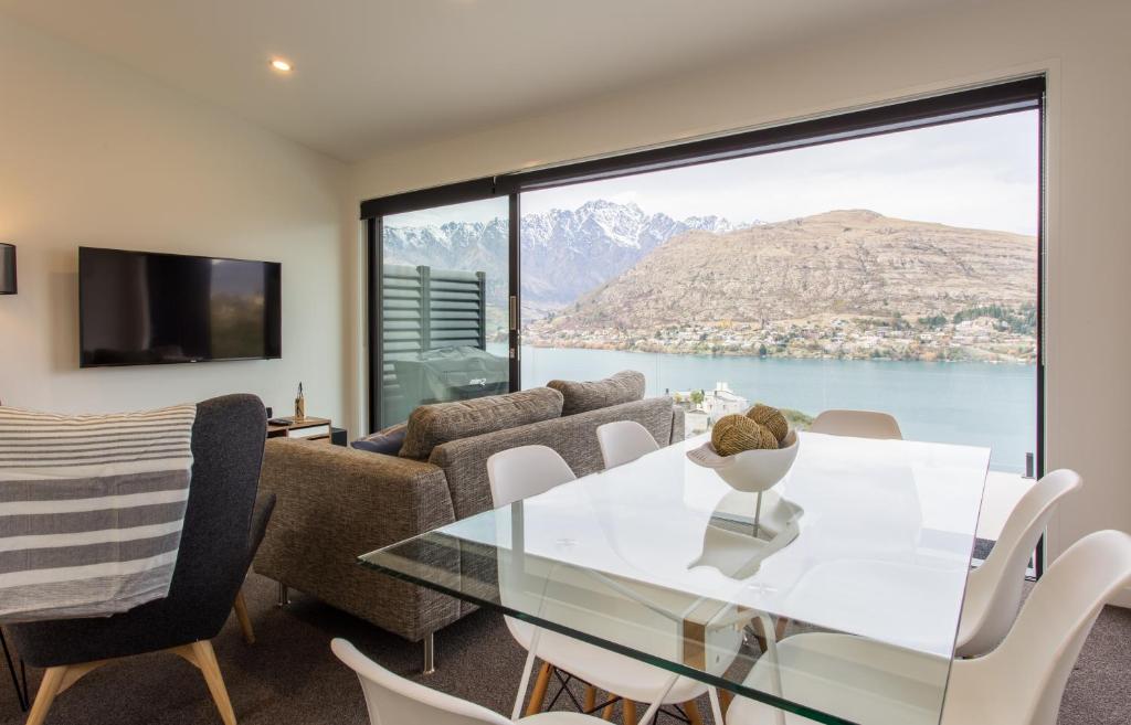 ein Wohnzimmer mit einem Tisch und Stühlen sowie einem großen Fenster in der Unterkunft Highland Views in Queenstown