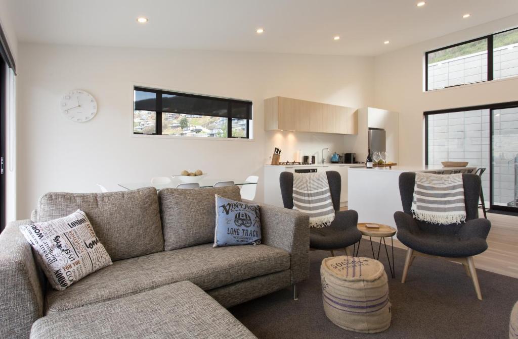 ein Wohnzimmer mit Couch und Küche in der Unterkunft Highland Views in Queenstown