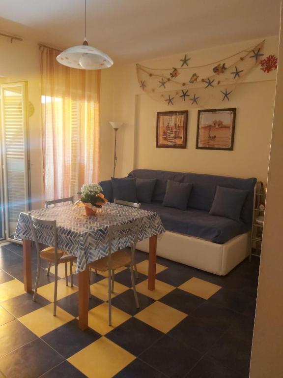 a living room with a blue couch and a table at SANT'ALESSIO BEACH HOLIDAY in SantʼAlessio Siculo