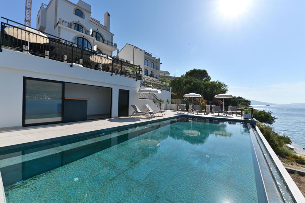 einem Pool vor einem Gebäude mit Meerblick in der Unterkunft Vila VitaMaris in Okrug Donji