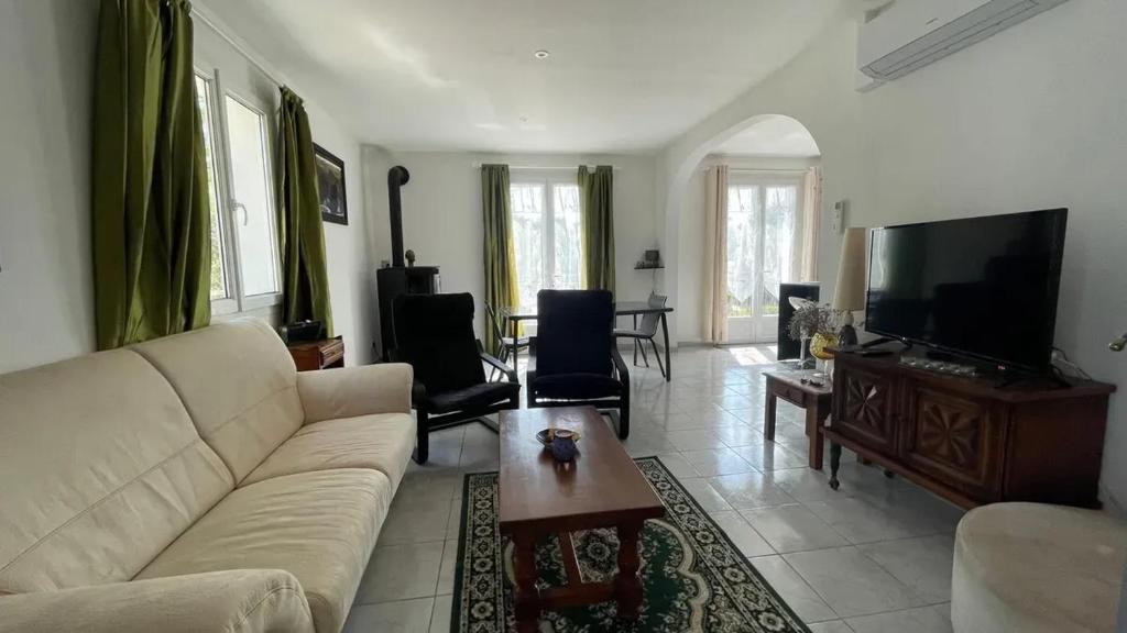 a living room with a couch and a flat screen tv at Maison charmante avec balcon près de Foulerot - 85 m² in Saint-Georges-dʼOléron