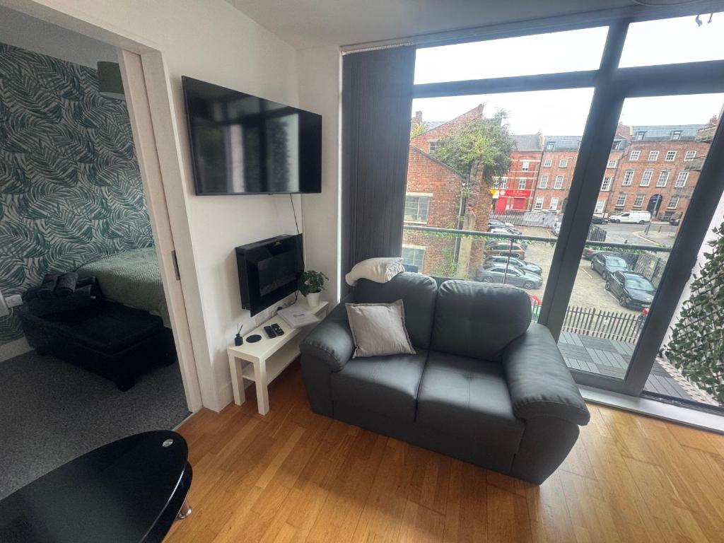 een woonkamer met een bank en een groot raam bij 2 Bedroom Apartment - Henry St Central Liverpool in Liverpool