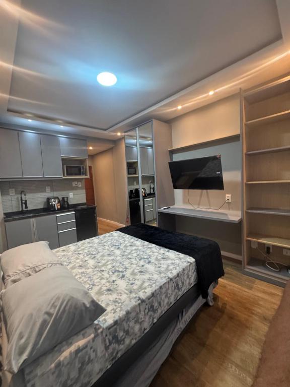 Un dormitorio con una cama grande y una cocina. en Studio CARIOCA, en Río de Janeiro