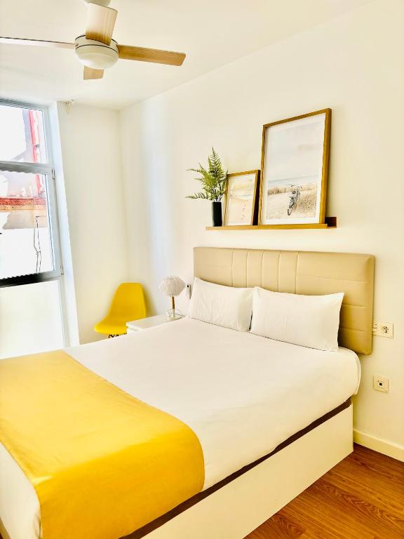 sypialnia z dużym łóżkiem i żółtym kocem w obiekcie LUMINOSO APARTAMENTO en el centro de Cádiz w Kadyksie