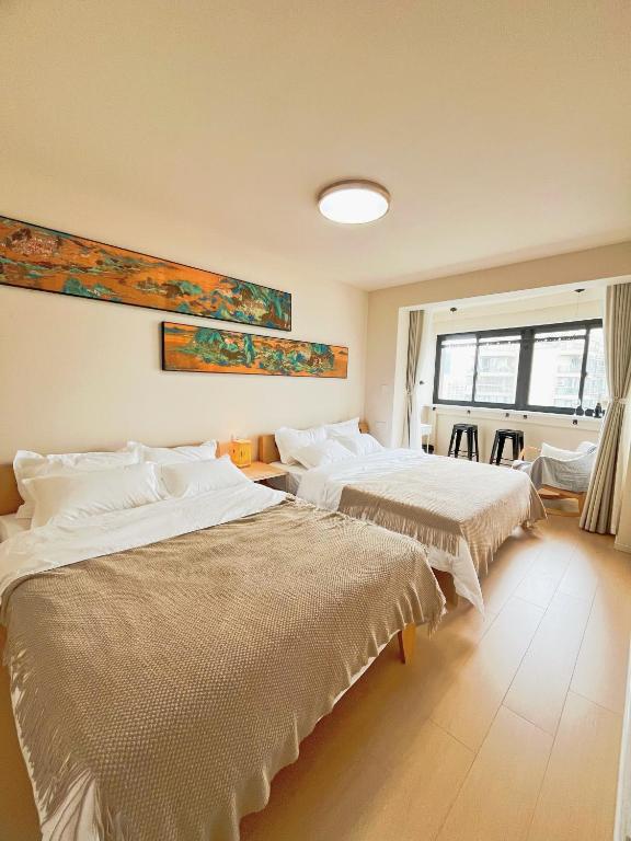 上海Uffice apartment的一间卧室，配有两张床和一扇窗户
