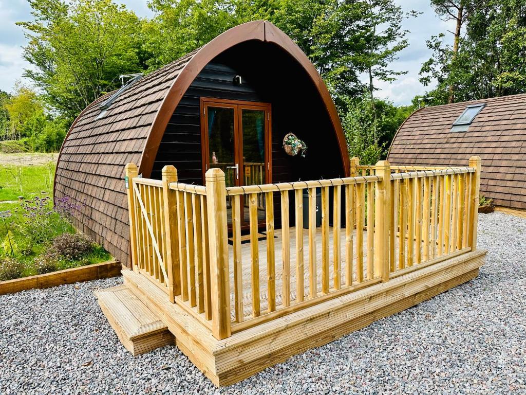 a small dome tent with a wooden fence in front of it at Homely Pod By The Moor & Fishing in Cheriton Bishop