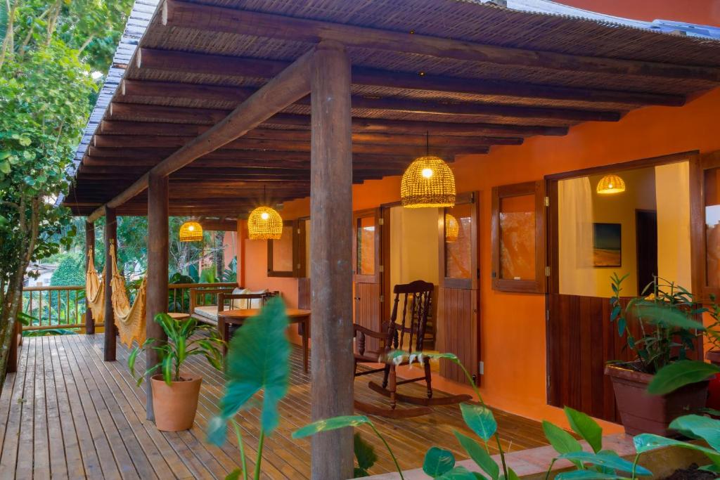 an outdoor deck with a pergola and a table and chairs at Pariri Suites in Trancoso