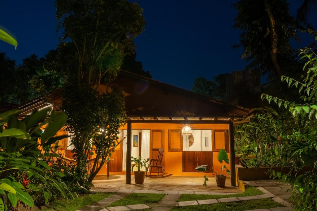 a house in the middle of a forest at night at Pariri Suites in Trancoso
