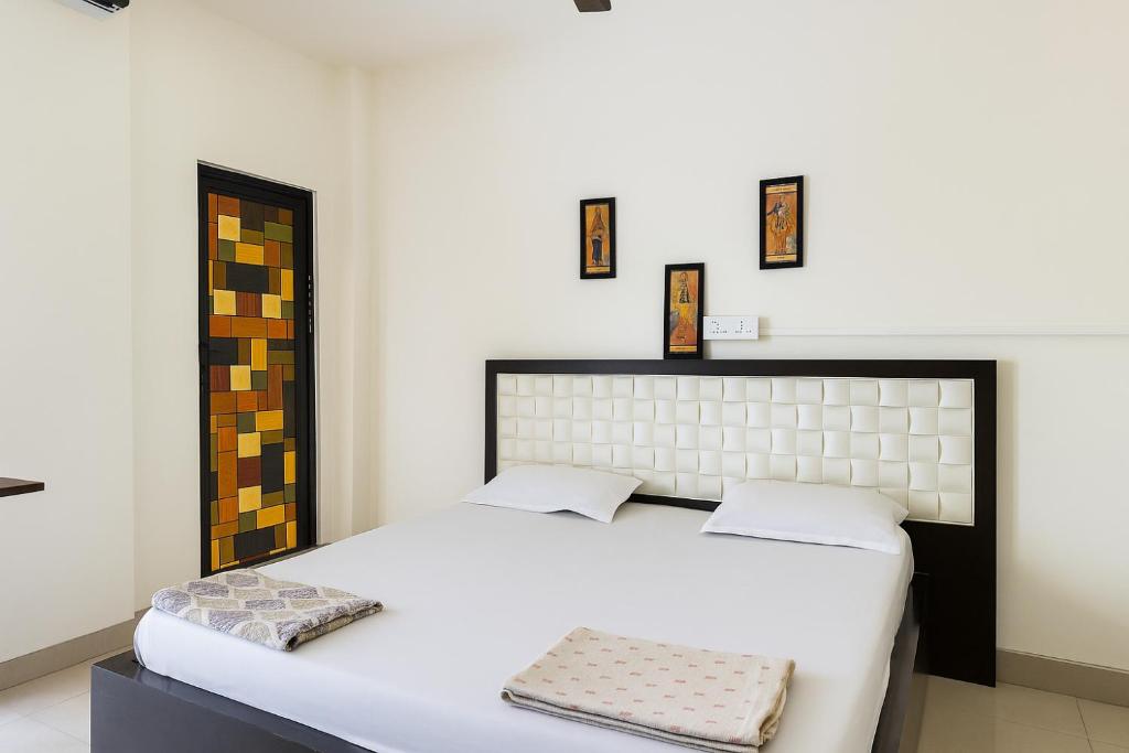 a bedroom with a large white bed with two pillows at Homestay Ac Dormitory in New Delhi