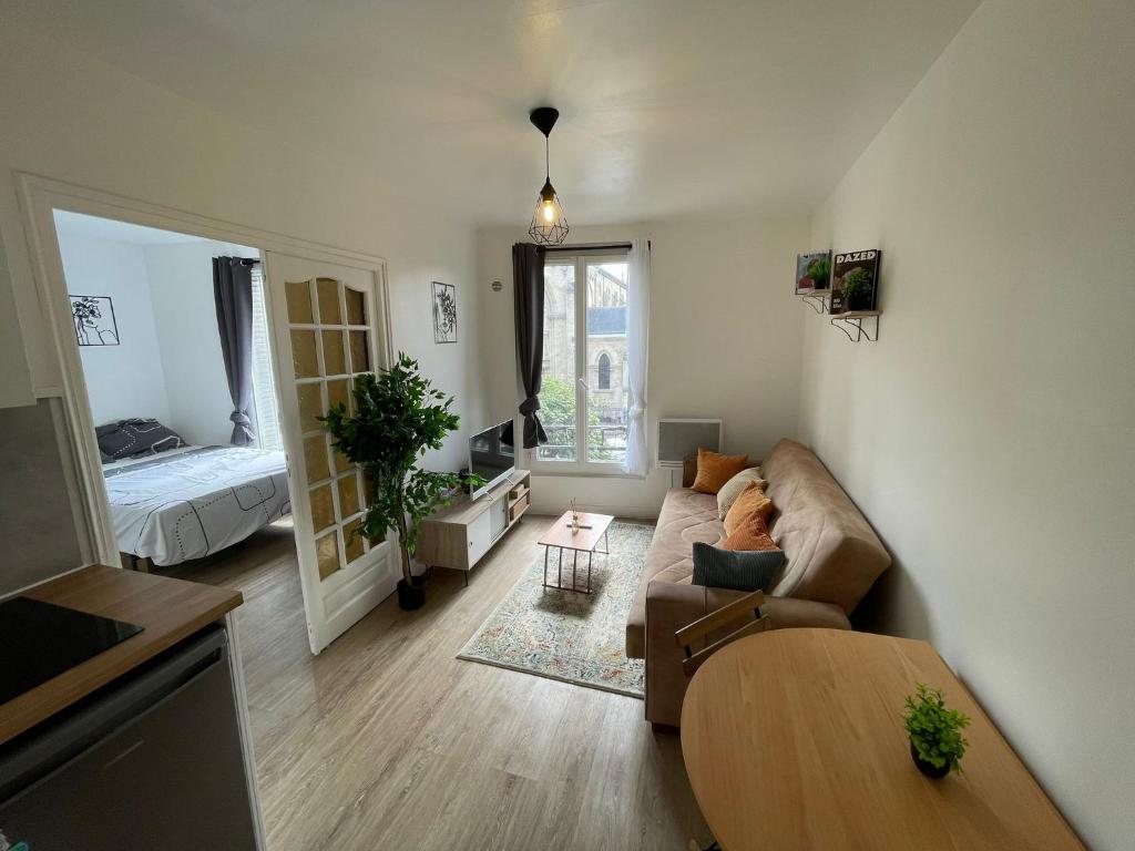 a living room with a couch and a table at Appartement 3 pers, métro direct in Aubervilliers