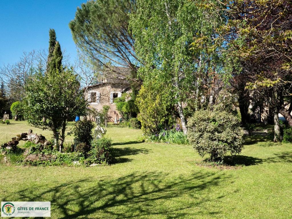 una vecchia casa in mezzo a un campo con alberi di Le Pigeonnier du Mas de Salles a Lugan