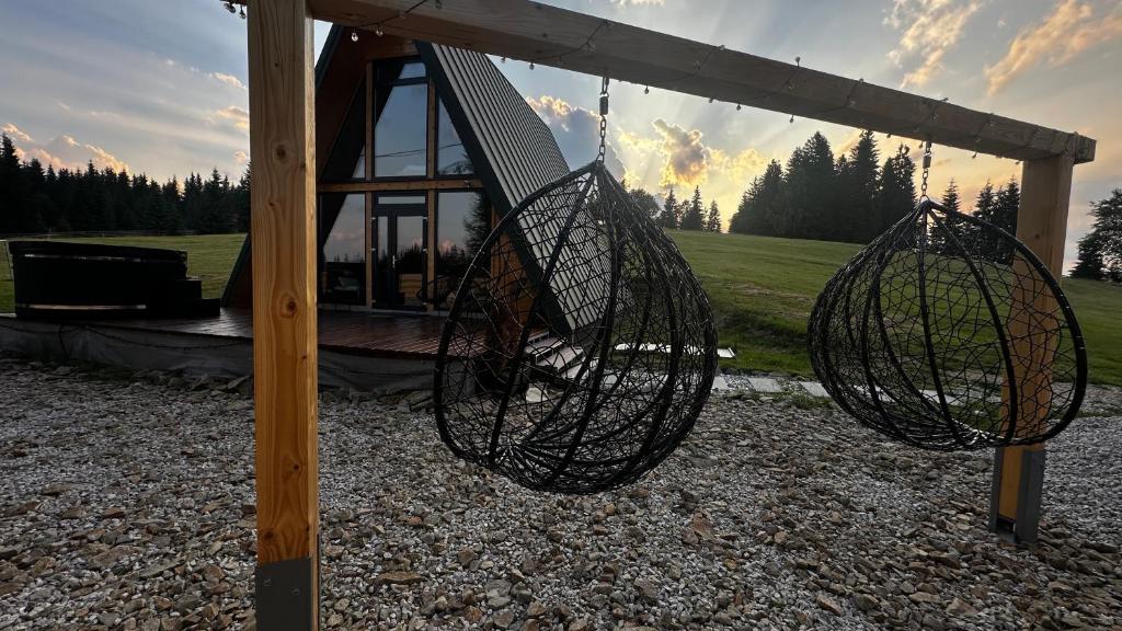 a swing set with two baskets on a pole at La Știubei Cabin in Mărişel