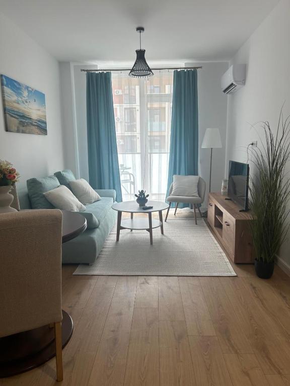 a living room with a blue couch and a table at A&A Appartment 2 in Timişoara