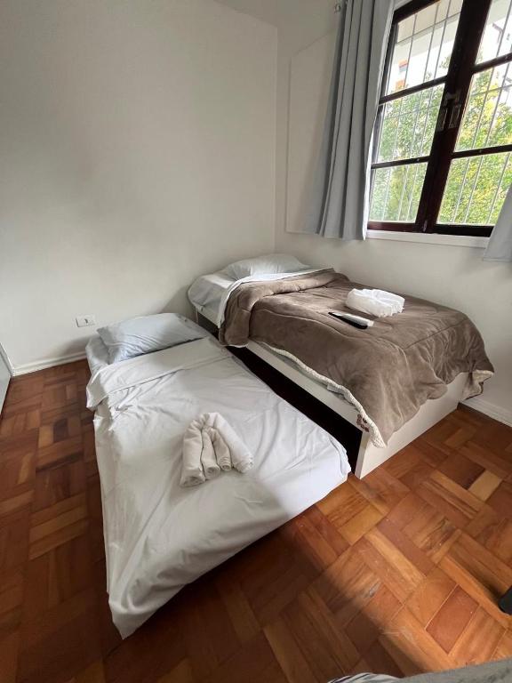 3 quartos a 400m do metro Ana Rosa في ساو باولو: سريرين في غرفة مع أرضية خشبية