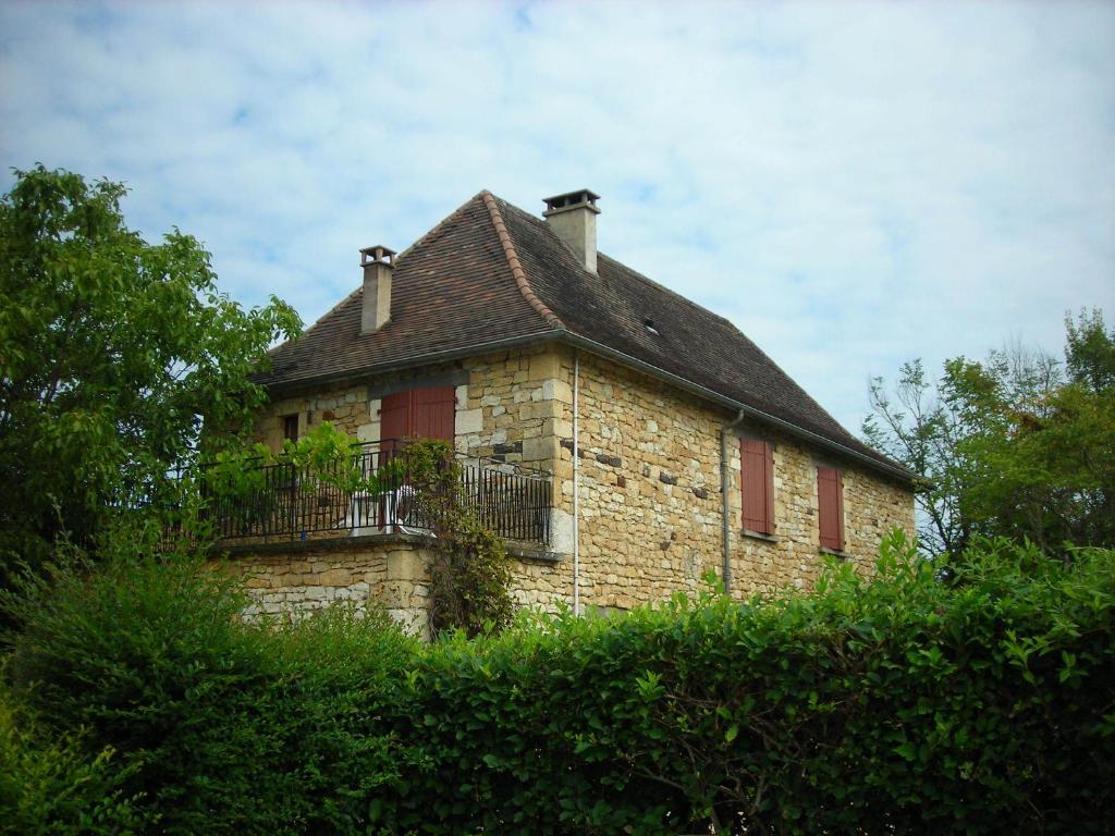 Nadaillac-de-RougeにあるHôtel Chastrusseの丘の上にバルコニー付きの古い石造りの家