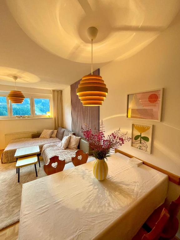 a bedroom with two beds and a table with flowers at Byt na svahu Sonnenalpe Nassfeld in Hermagor