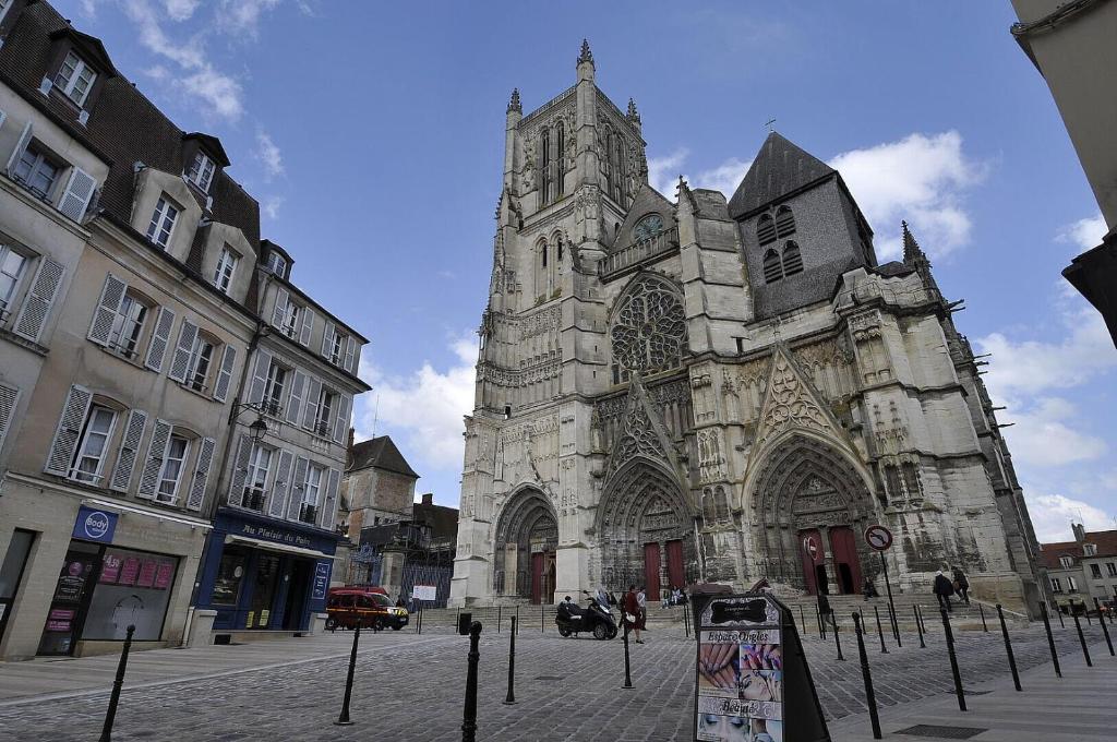 an old stone church with a tower on a street at Beautiful 2-room apartment - Meaux - near Disneyland in Meaux