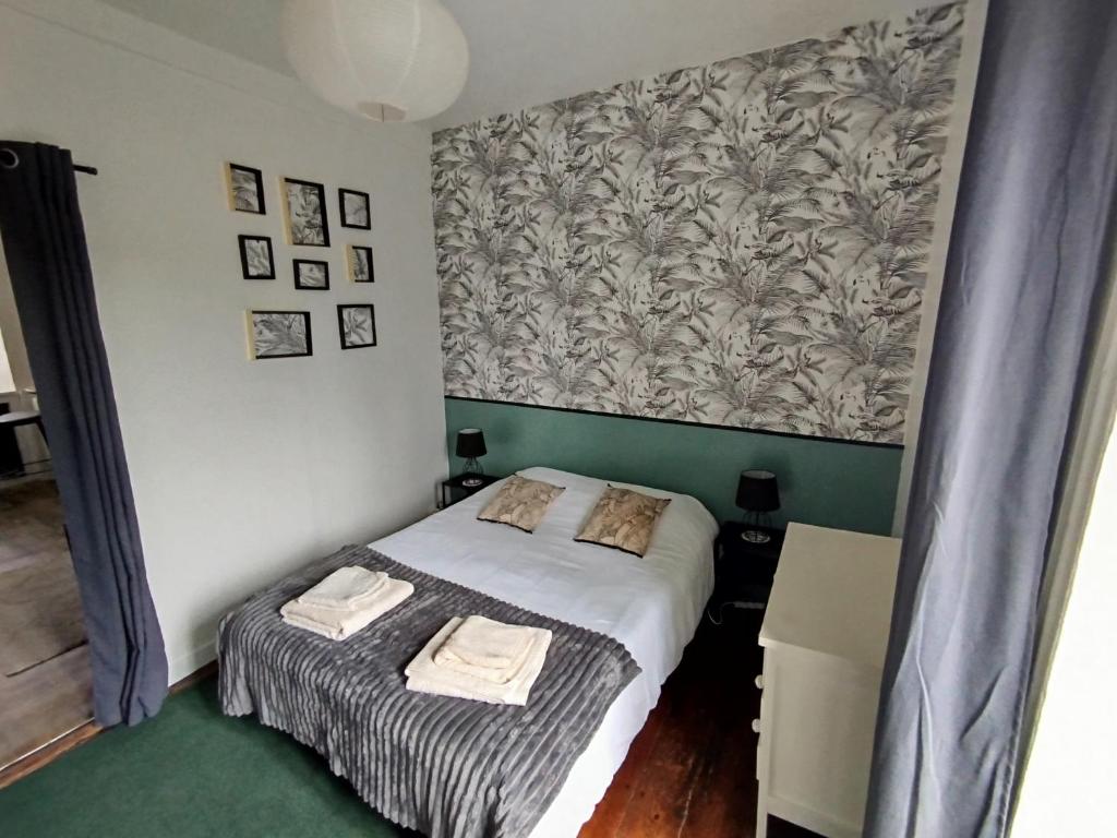 Habitación pequeña con cama y papel pintado en T2 cozy avec vue sur Morlaix, en Morlaix