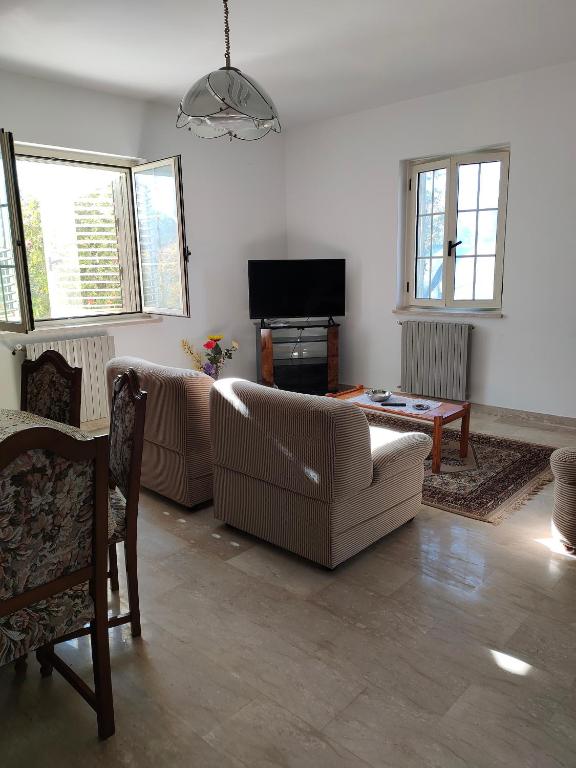 a living room with two couches and a tv at Holiday Calabria Rooms in Lamezia Terme
