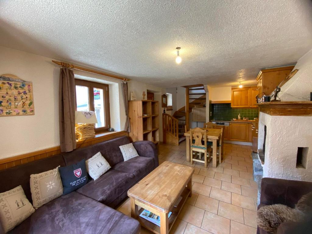 un soggiorno con un divano e un tavolo di Maison de village aux Allues proche commerces et télécabine pour 6 pers. - FR-1-411-987 a Les Allues