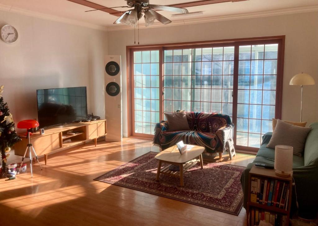 a living room with a couch and a tv at A spacious, cosy, independent house in Pohang