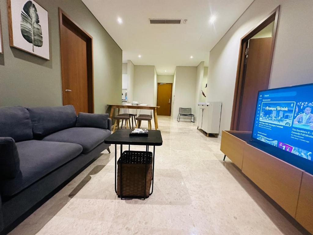 a living room with a couch and a flat screen tv at Sky Suites Home Stay AT kLCC AREA in Kuala Lumpur