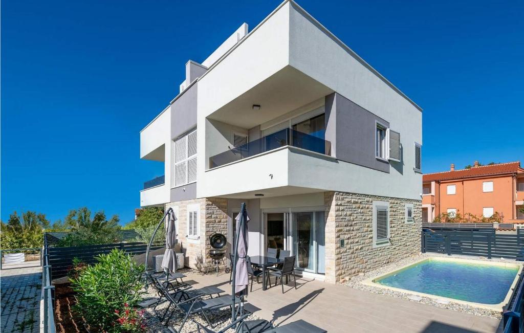 a white house with a swimming pool in front of it at Villa Valencan 3 in Mednjan